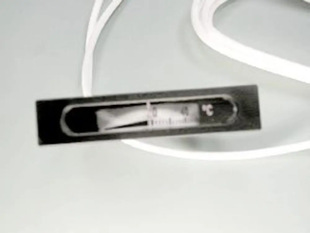 Thermometer von Remeha, in einem schmalen schwarzen Gehäuse mit einer Anzeige für Temperaturwert und einer Kunststoffummantelung, liegt auf einer glatten Oberfläche.